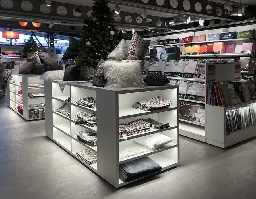 Weiße Regale mit LED-Beleuchtung und versteckter Elektrifizierung in einem Bettwäsche-Shop